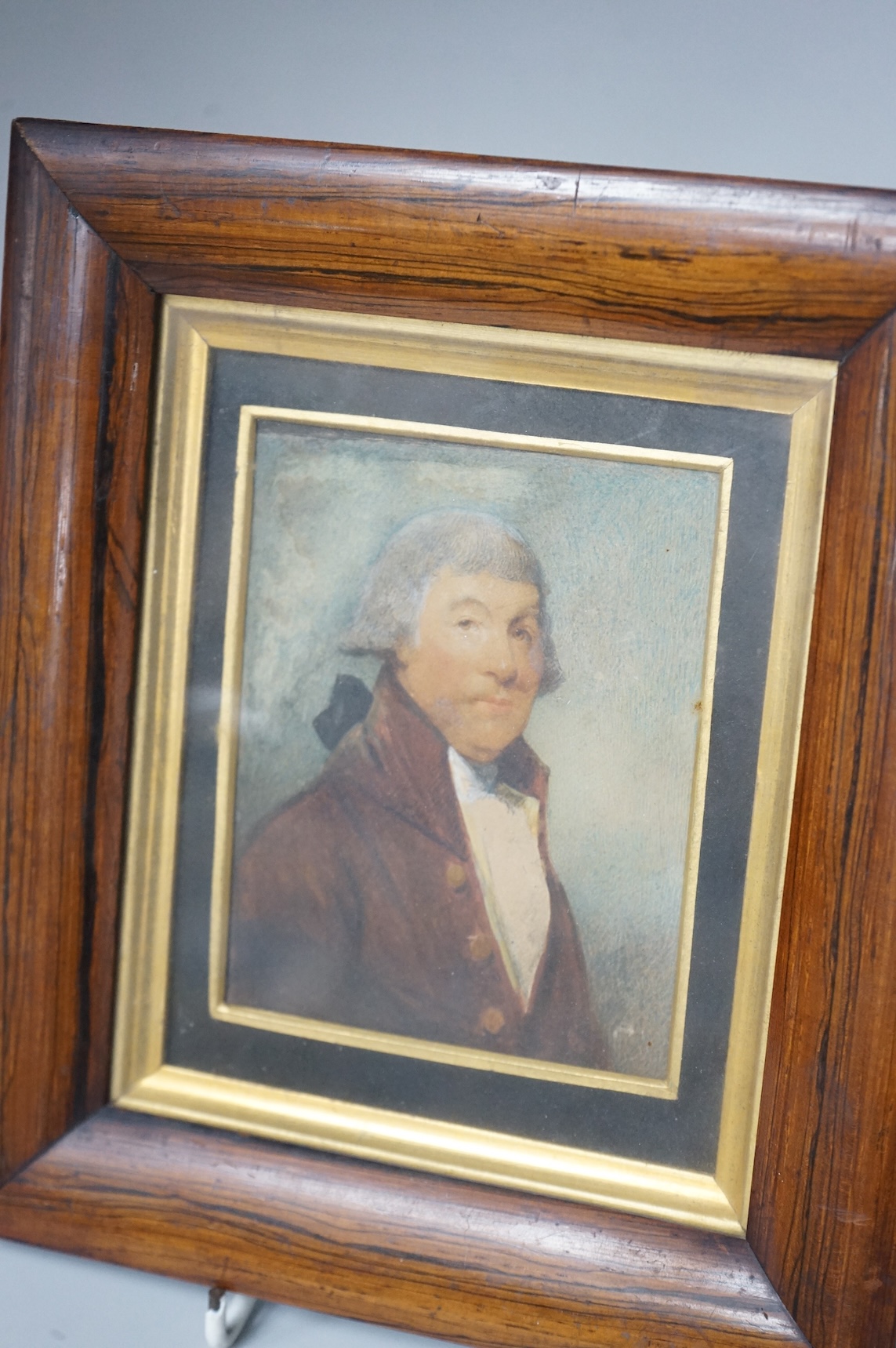 Georgian School, Portrait miniature of a gentleman wearing a frock coat and wig, watercolour on card, framed, 11 x 8cm